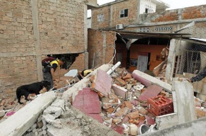 رجال شرطة يفتشون أنقاض مبنى تعرض للدمار بفعل زلزال في الاكوادور