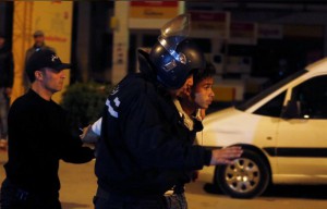 شرطيان من مكافحة الشغب يعتقلان رجلا خلال احتجاجات في العاصمة تونس يوم العاشر من يناير
